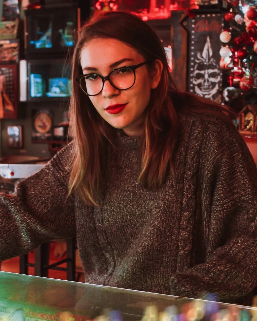 Maria in a knitted jumper and red lipstick in warm red light