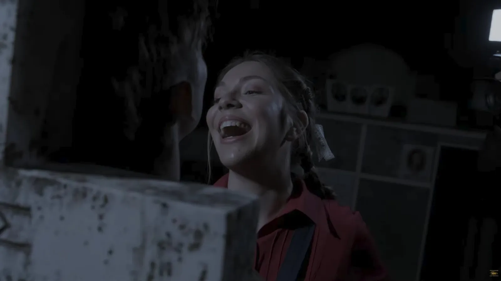 Maria laughing in a red shirt on the set of the Metronomos music video