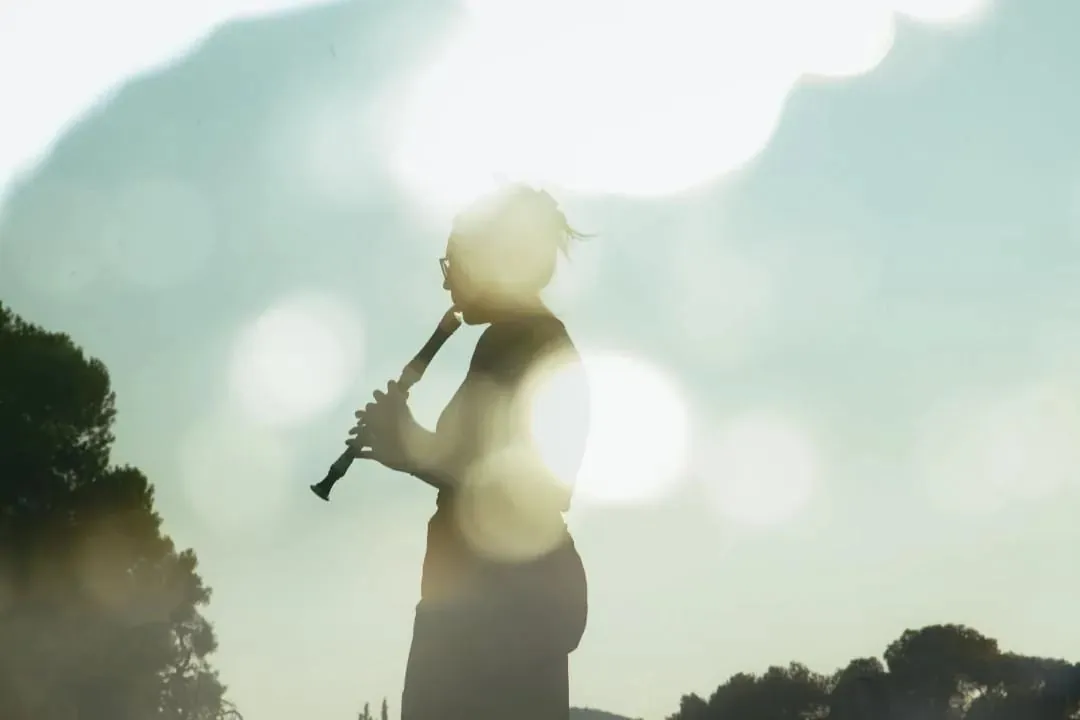 Silhouette of Maria playing the saxophone against the sun