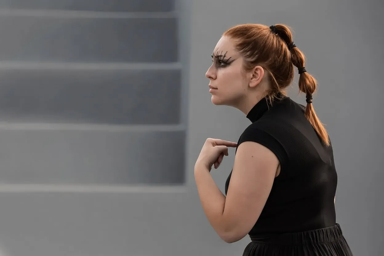 Maria as Electra in profile, in a black dress with dramatic eye make-up